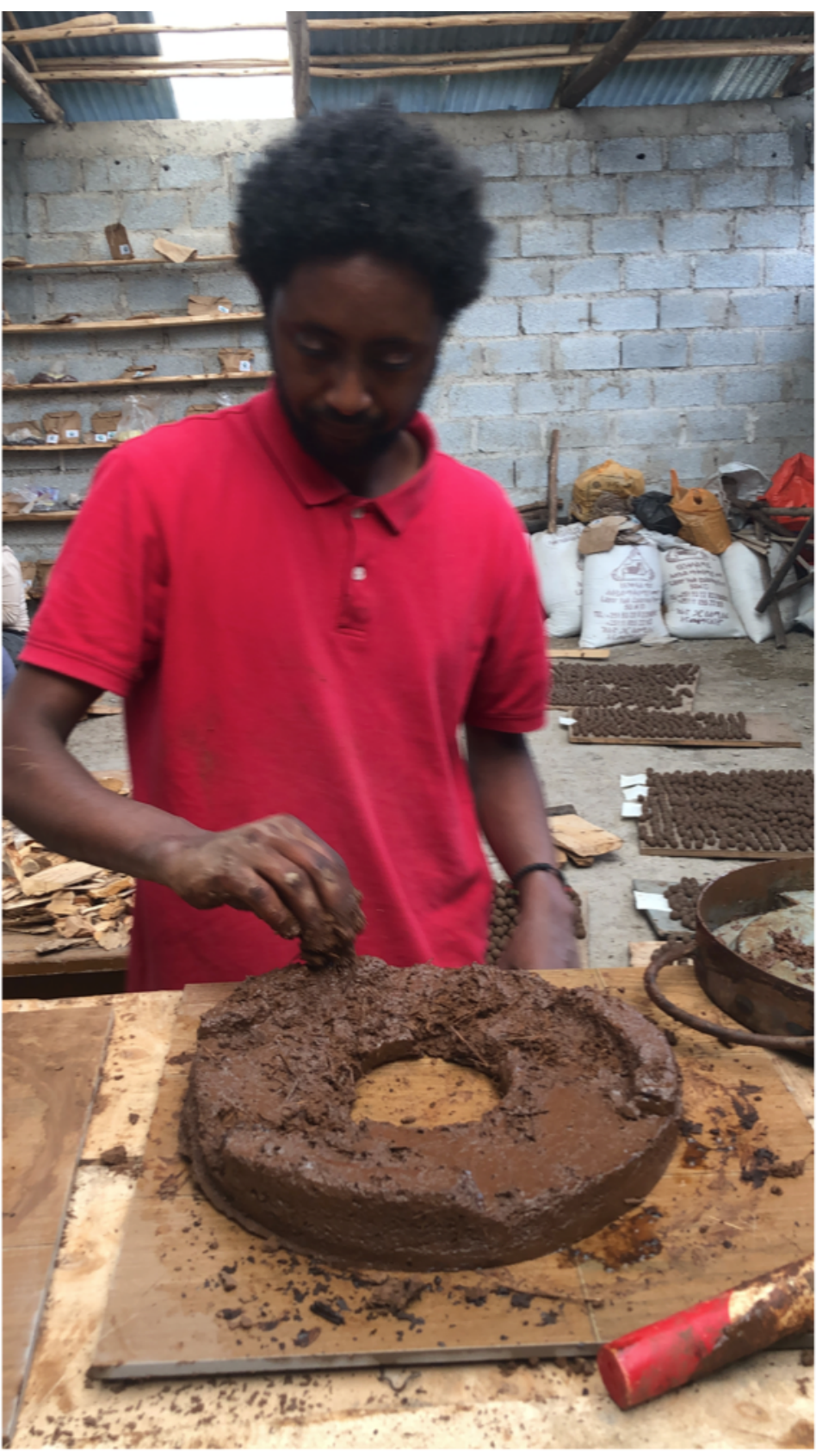 Producer shaping a Noah stove base by hand from clay in a production workshop in Welkite, Ethiopia