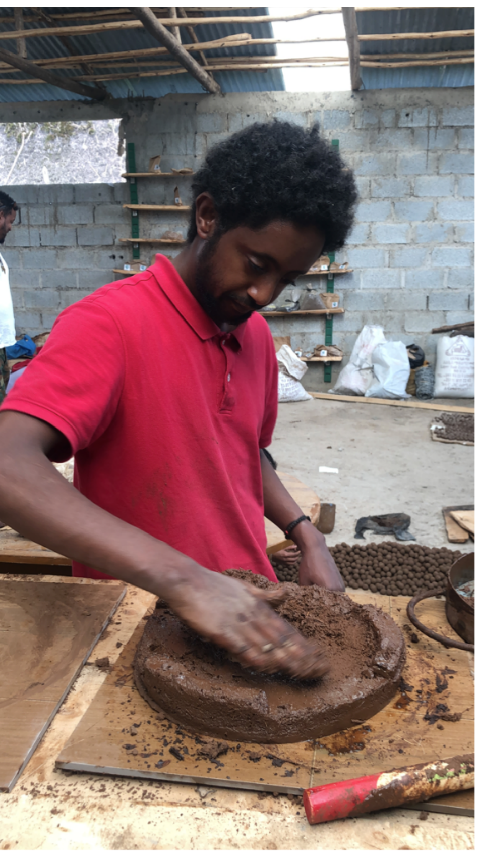 Producer pressing and smoothing clay into a ring-shaped mold by hand