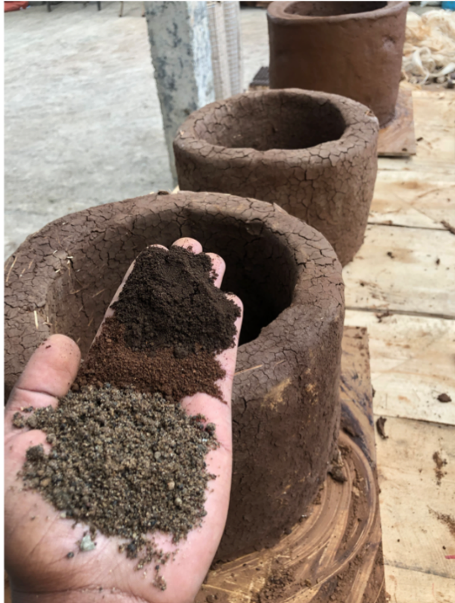 Second layered soil and sand sample held over a finished clay stove body